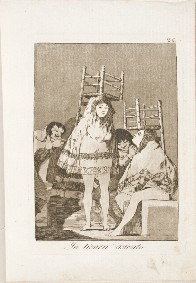 A black and white print of two women, one standing and the other sitting, with upturned chairs on their heads, garments over their heads with legs exposed, while two men laugh at them