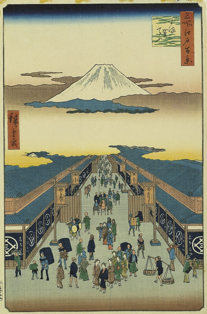 A color print showing a bird's eye view of figures walking through a shop-lined street, with the peak of a white mountain rising above clouds in the center
