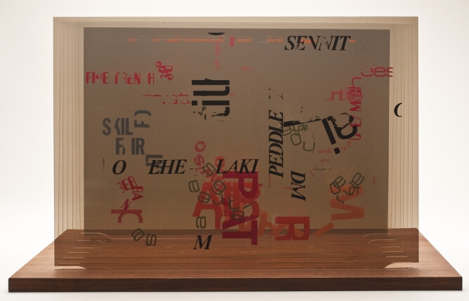 Fragments of black and red text printed on sheets of plexiglass set into a wooden base and assembled to form an abstract multi layered composition