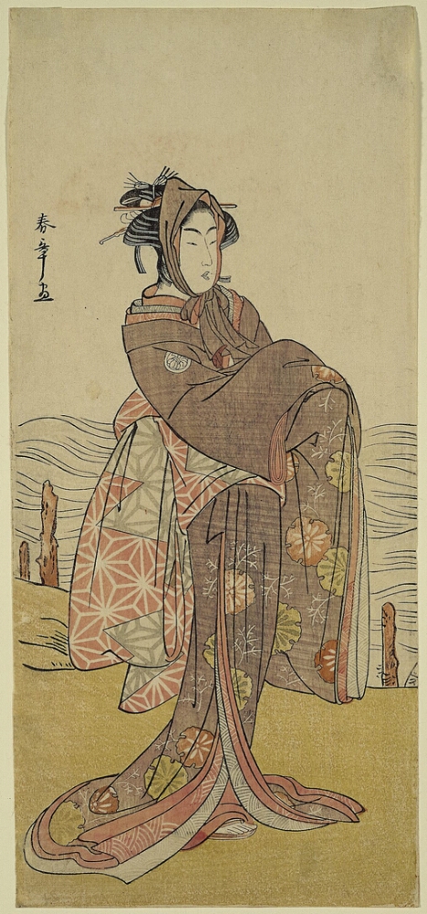 A color print of a standing man wearing a headwrap and dressed in a woman's kimono with long sleeves and a droopy sash in the back