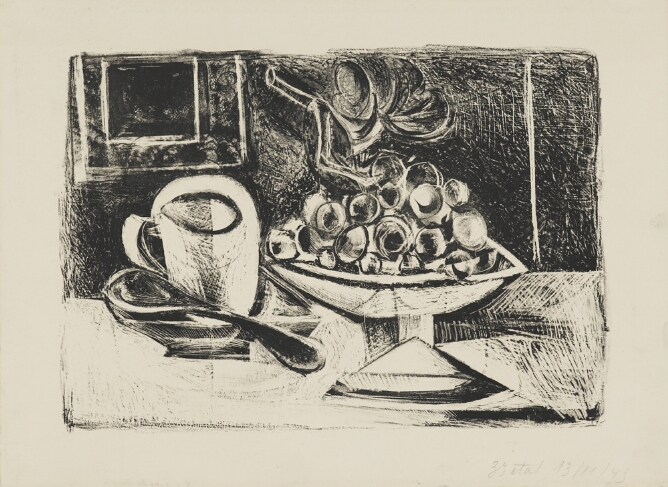 A black and white, abstract print of fruit on a stand next to a cup, saucer and spoon on a table