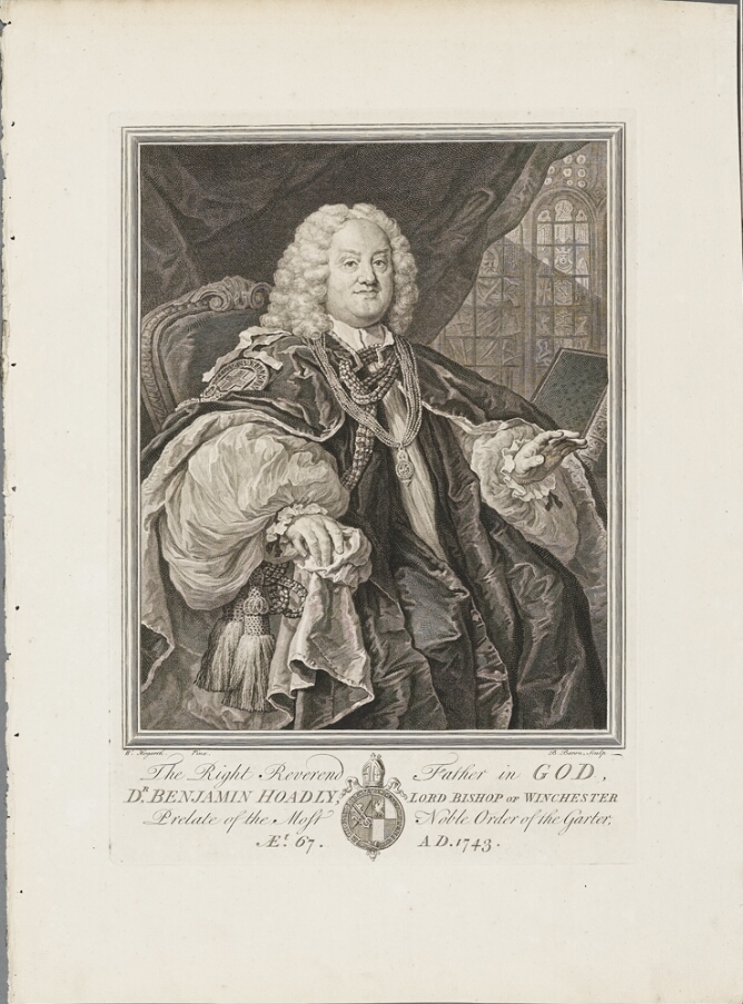 A black and white portrait of a man sitting in chair in a room with stained glass windows. He wears opulent clothing, a wig and gestures with one hand