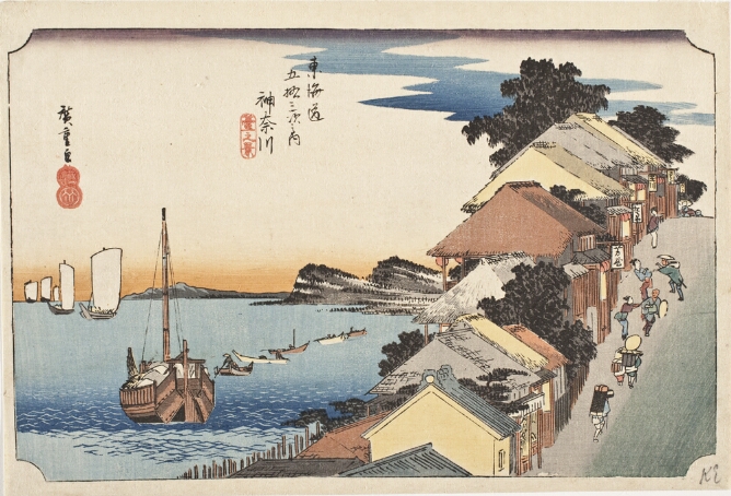 A color print of figures walking up a steep street lined with merchant shops alongside a seashore with boats at sail to the viewer's left