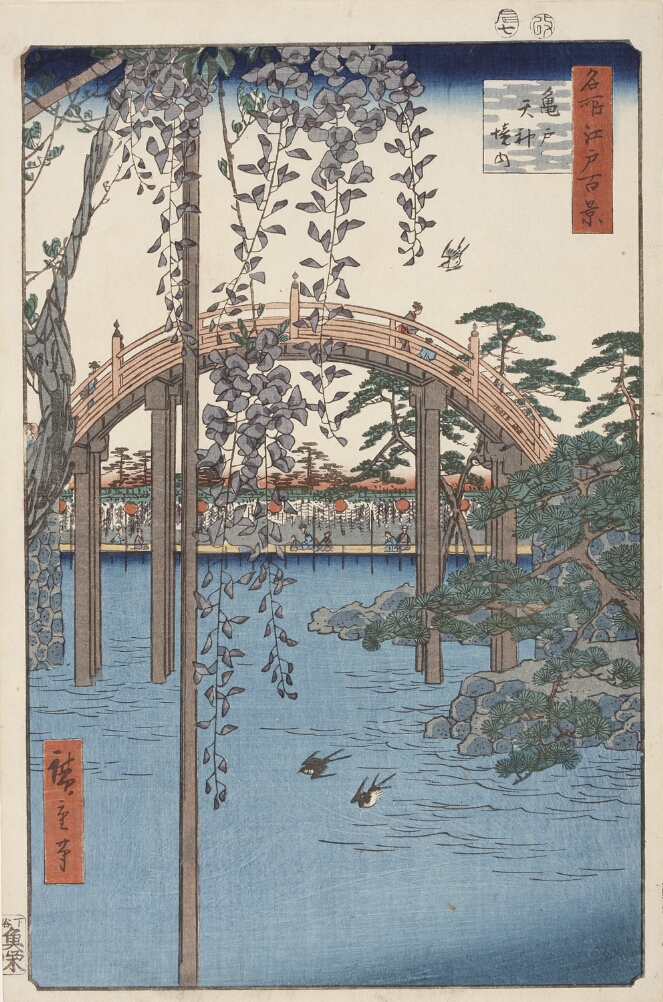 A color print showing a view through hanging wisteria flowers of figures walking along an arched bridge over a lake